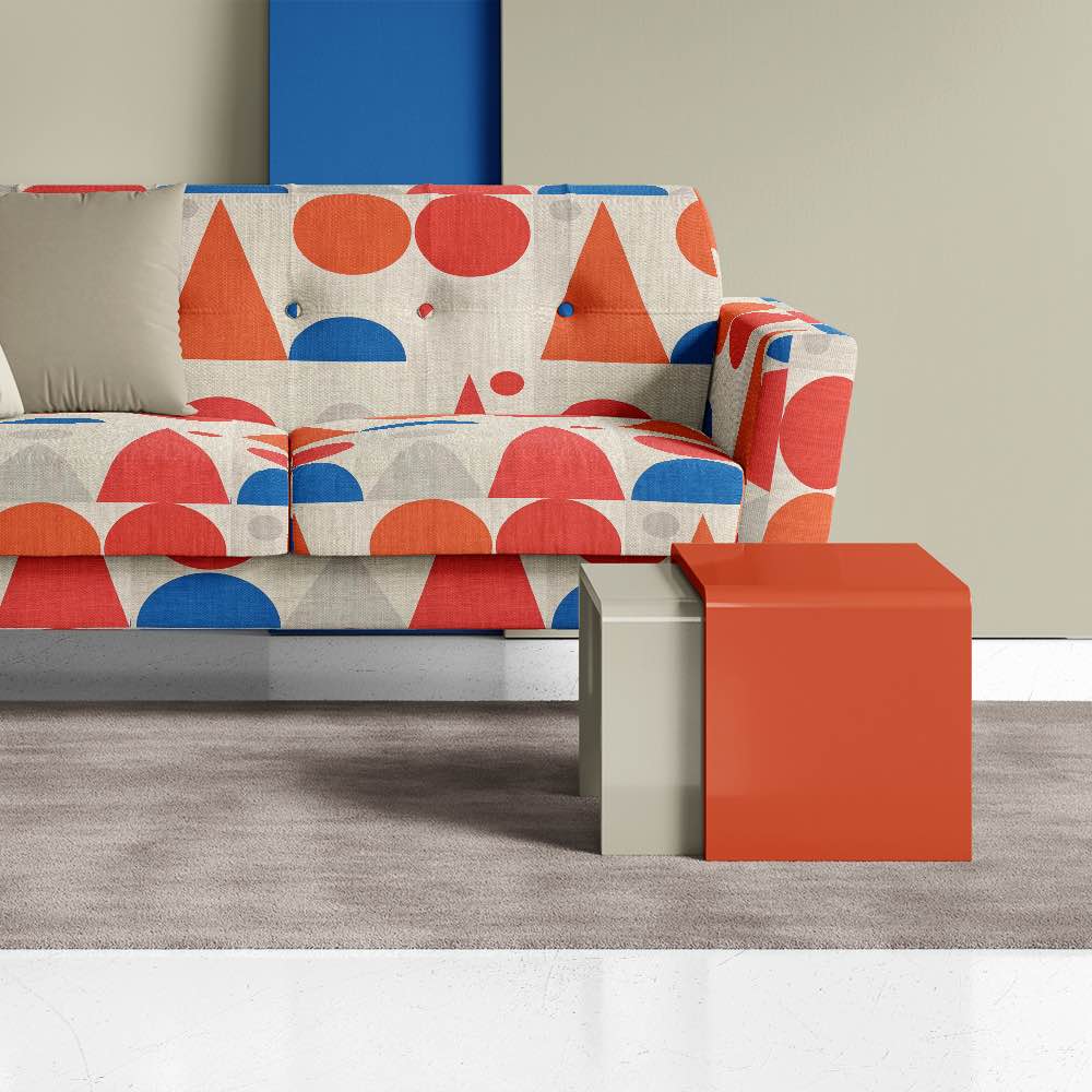 Sofa view of Cubism No.9 upholstery fabric in orange, red, blue, and neutral with Cubism art movement design