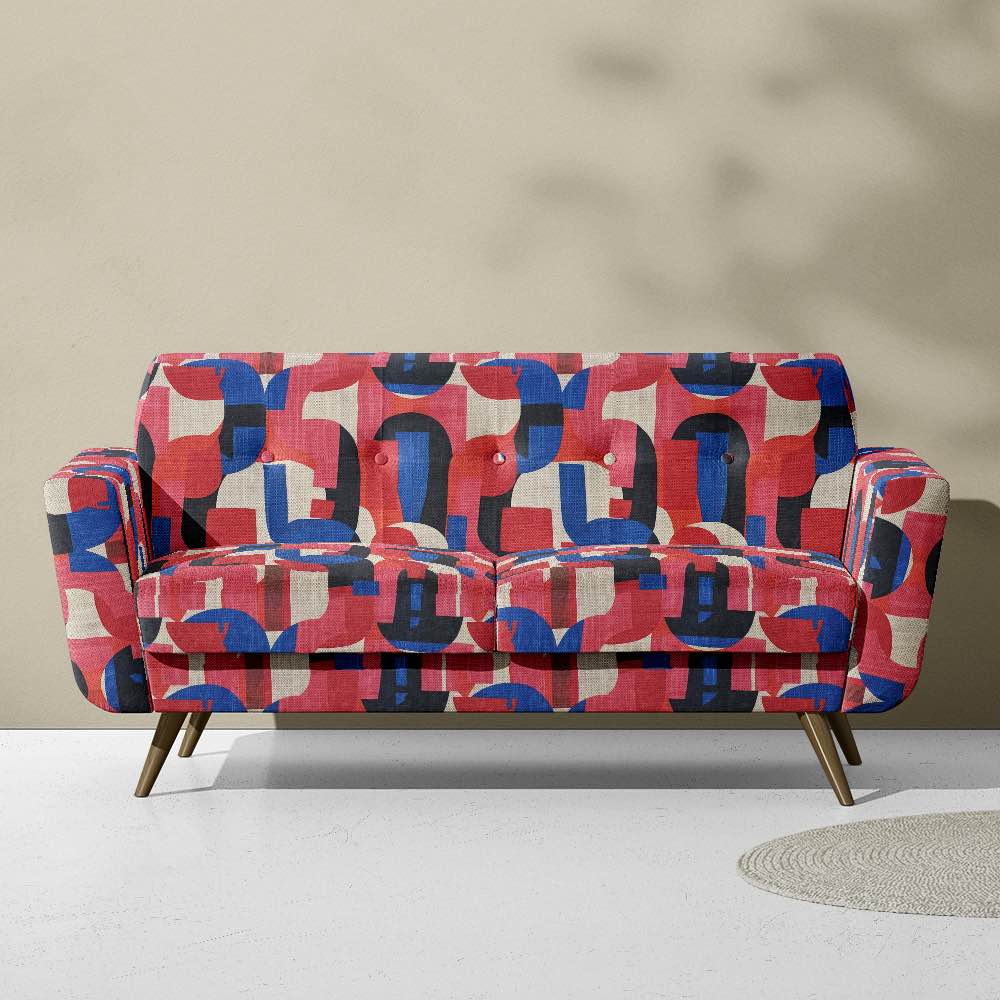 Upholstered view of Dimension No.2 upholstery fabric in pinks and blues with overlapping geometric shapes